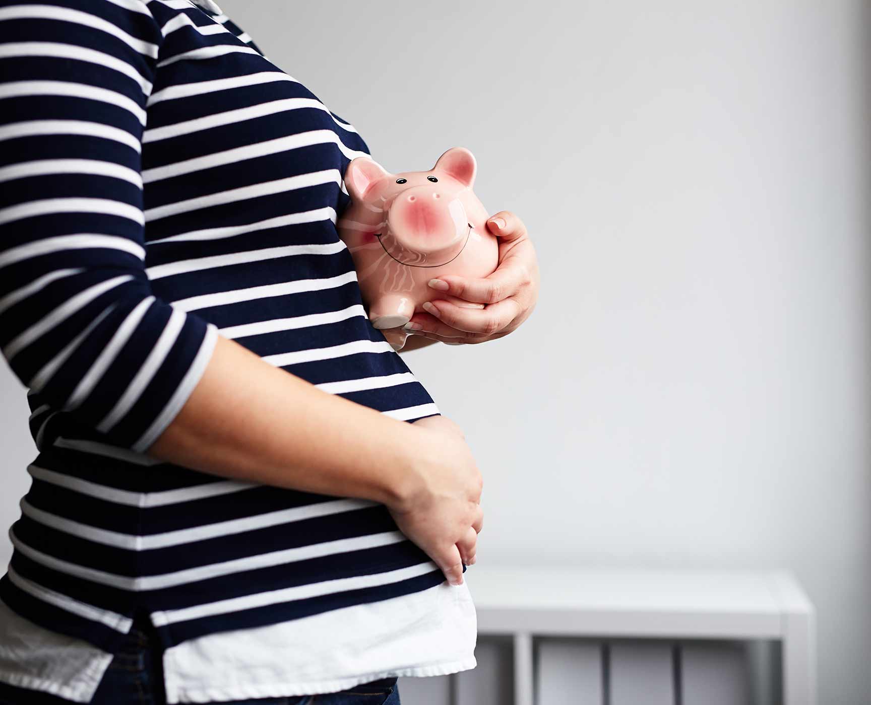 pregnant woman with a piggy bank