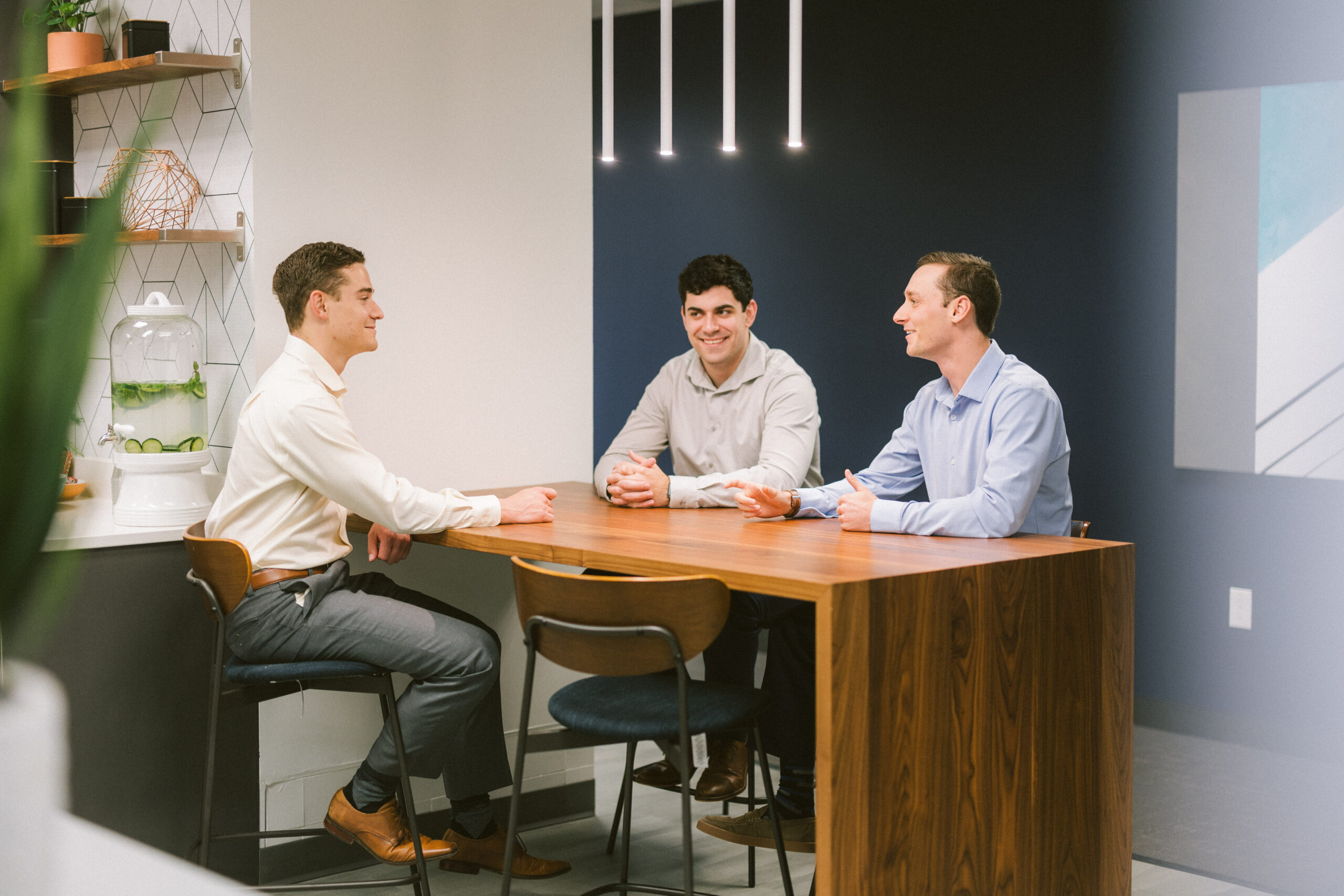 3 professional men talking sitting at a table