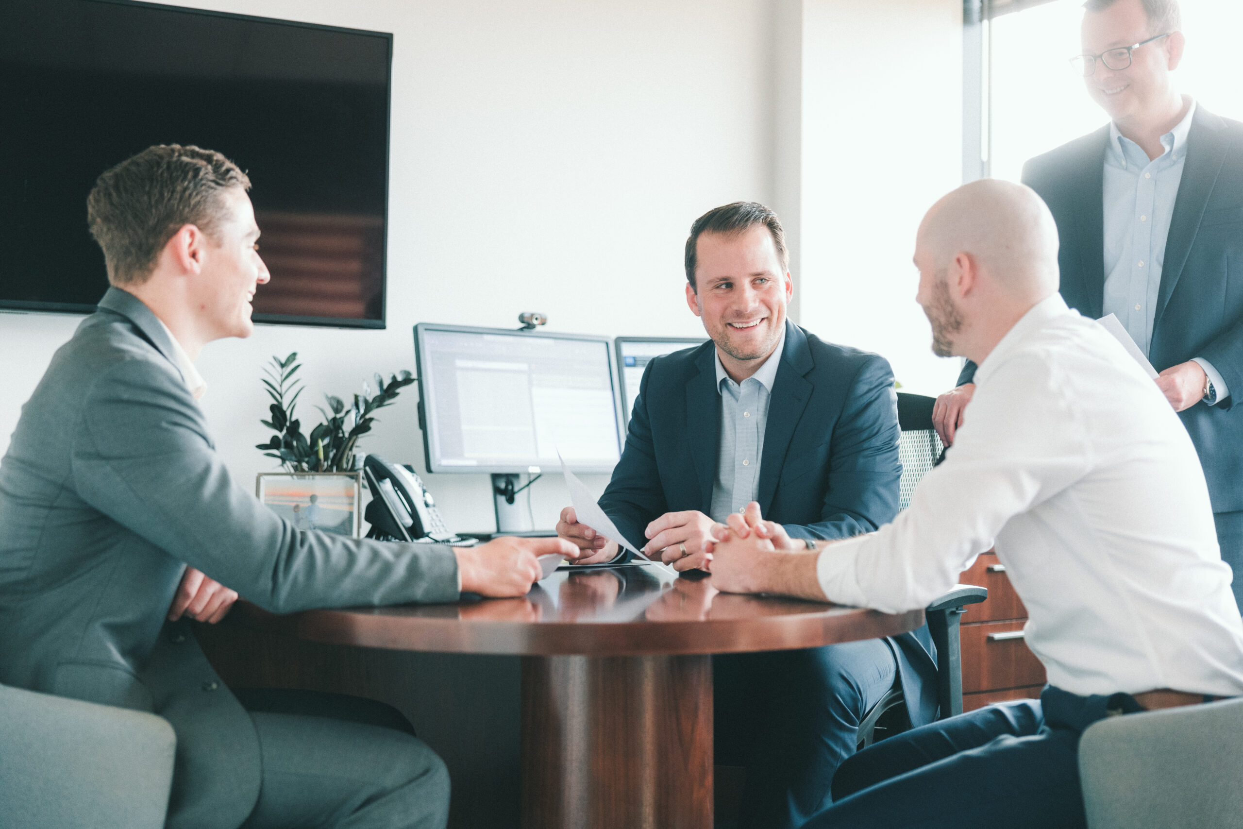 Four professional Men talking at a desk